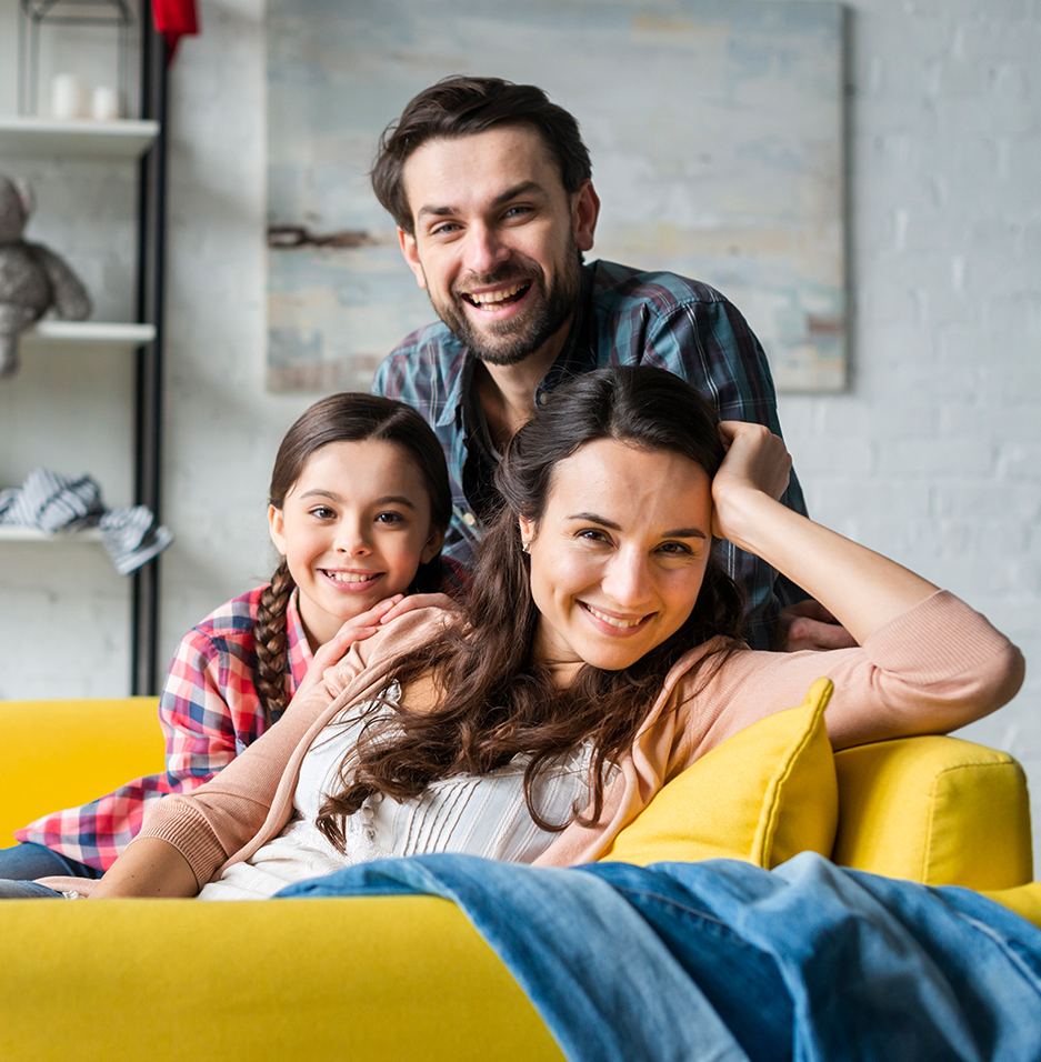 Familia feliz sobre sofá amarillo